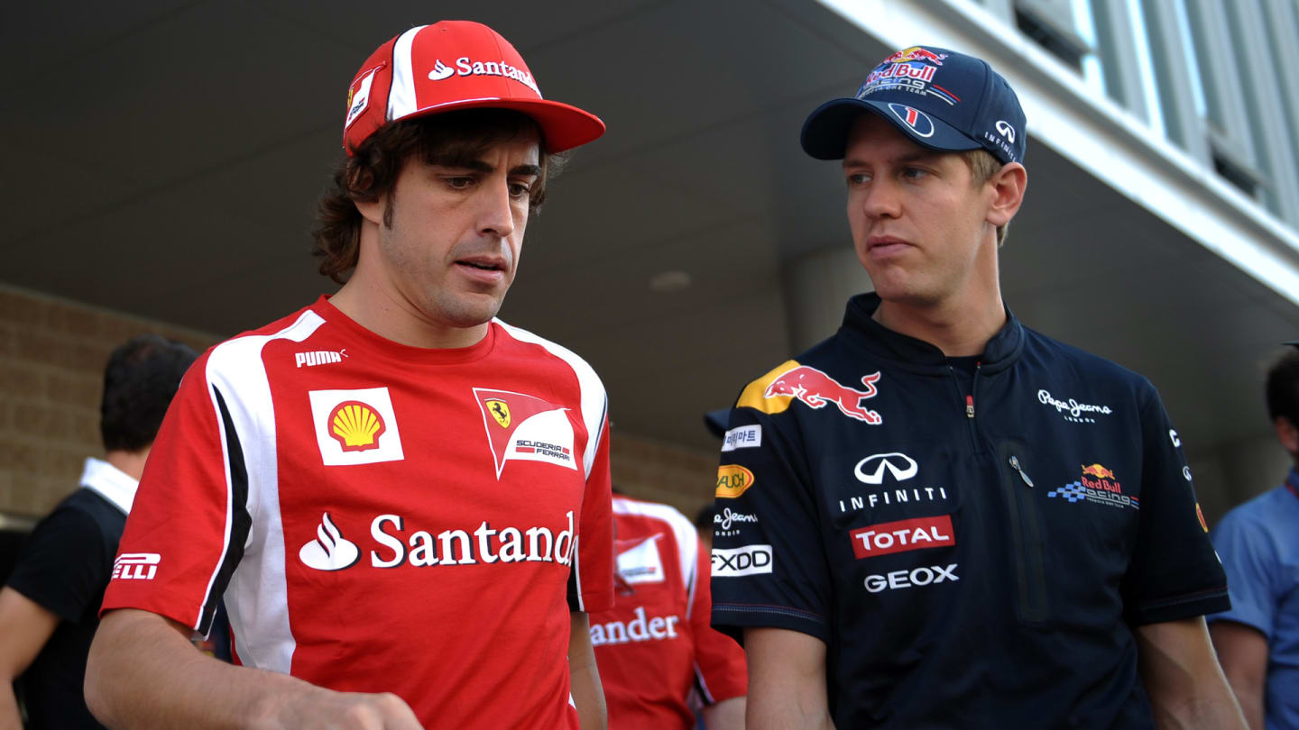 Red Bull-Renault driver Sebastian Vettel (R) of Germany talks to Ferrari driver Fernando Alonso of