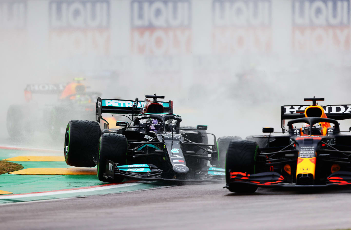 IMOLA, ITALY - APRIL 18: Lewis Hamilton of Great Britain driving the (44) Mercedes AMG Petronas F1 Team Mercedes W12 drives off a raised kerb behind Max Verstappen of the Netherlands driving the (33) Red Bull Racing RB16B Honda during the F1 Grand Prix of Emilia Romagna at Autodromo Enzo e Dino Ferrari on April 18, 2021 in Imola, Italy. (Photo by Bryn Lennon/Getty Images)
