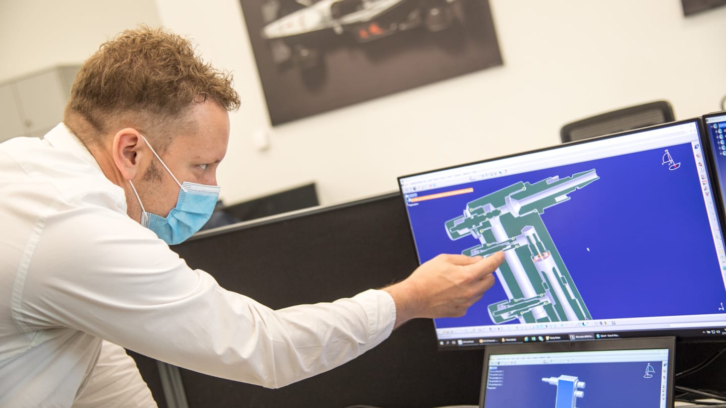 Ben Hodgkinson, Head of Mechanical Engineering at Mercedes-AMG HPP, with technical drawings of the