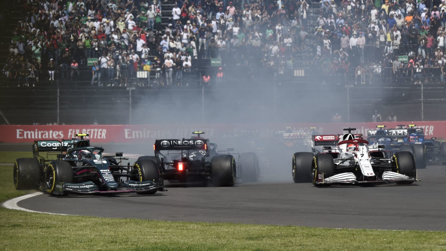 Mercedes' Finnish driver Valtteri Bottas (C) skidds on the track between Aston Martin's German