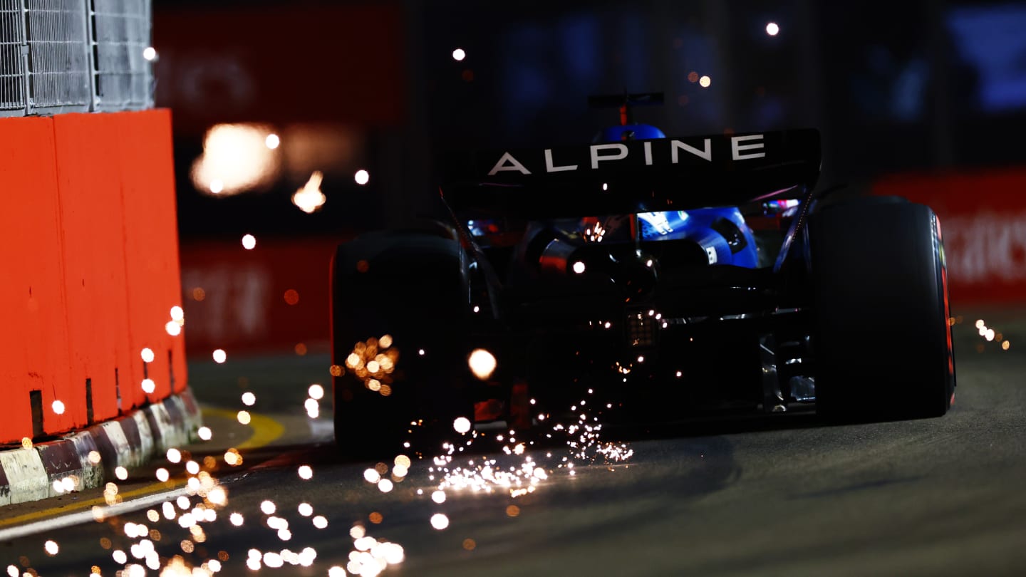 SINGAPORE, SINGAPORE - SEPTEMBER 30: Sparks fly behind Fernando Alonso of Spain driving the (14)