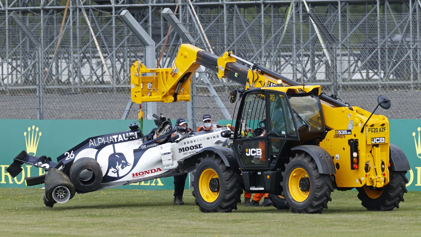 Marshals in face coverings take away the car of AlphaTauri's Russian driver Daniil Kvyat after a crash during the Formula One British Grand Prix at the Silverstone motor racing circuit in Silverstone, central England on August 2, 2020. (Photo by ANDREW BOYERS / POOL / AFP)