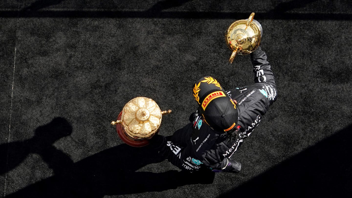 Mercedes' British driver Lewis Hamilton celebrates with his trophy on the podium after winning the