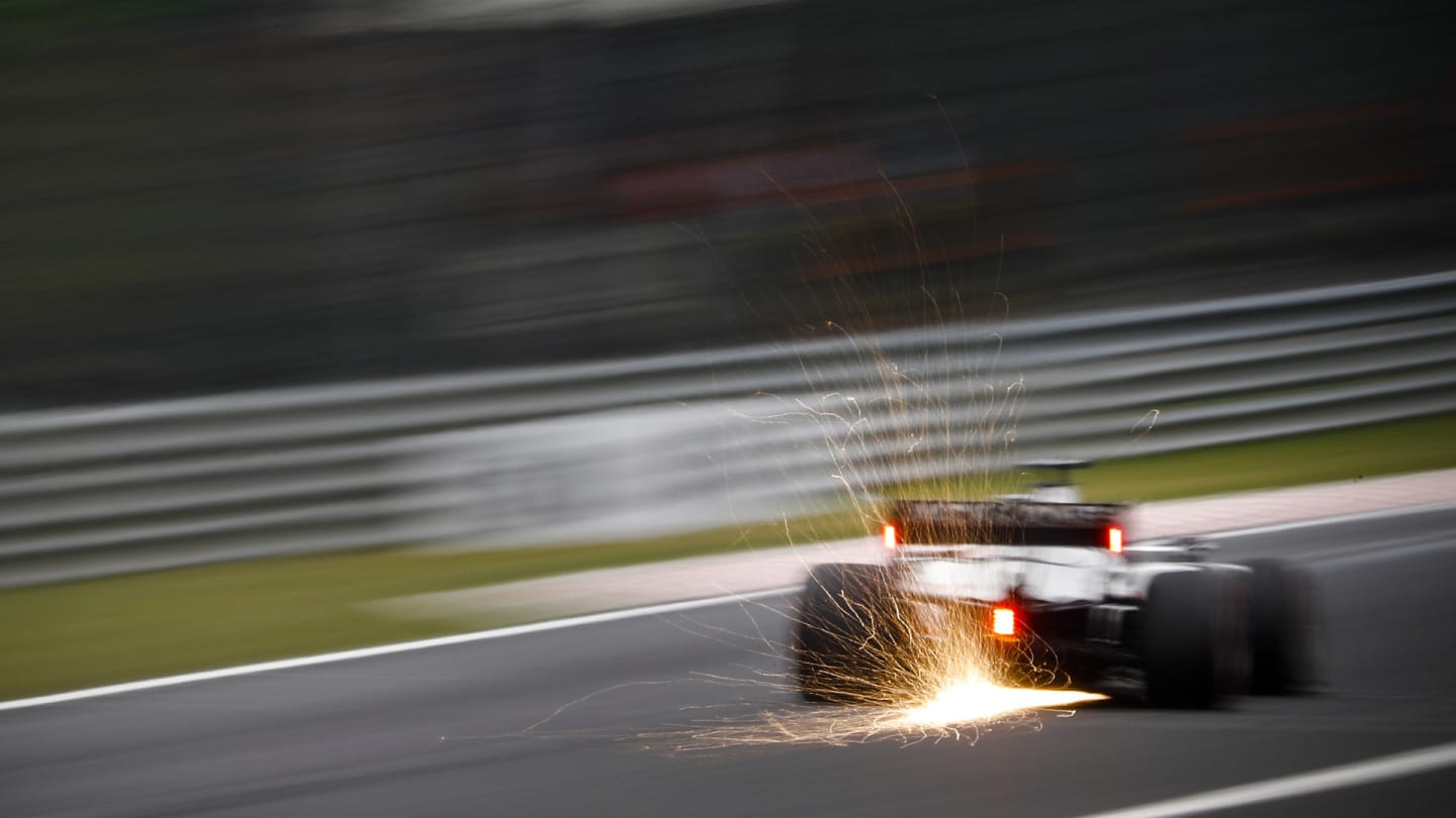 Sparks fly from the rear of Romain Grosjean, Haas VF-20