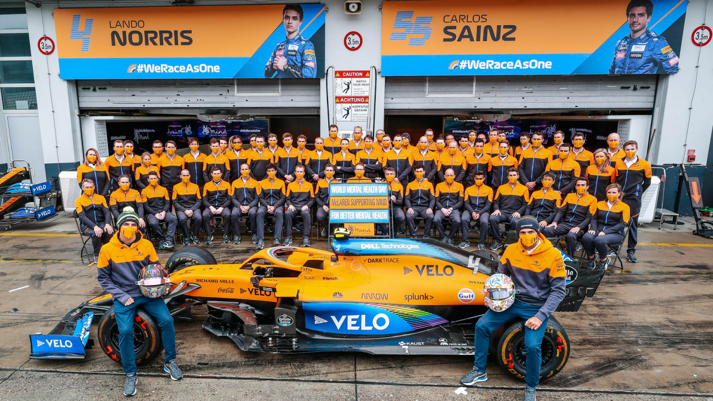 Sainz and Norris pose with the MCL35 and their team for World Mental Health Day. The team and their fans have raised nearly £200k since July for the charity Mind.