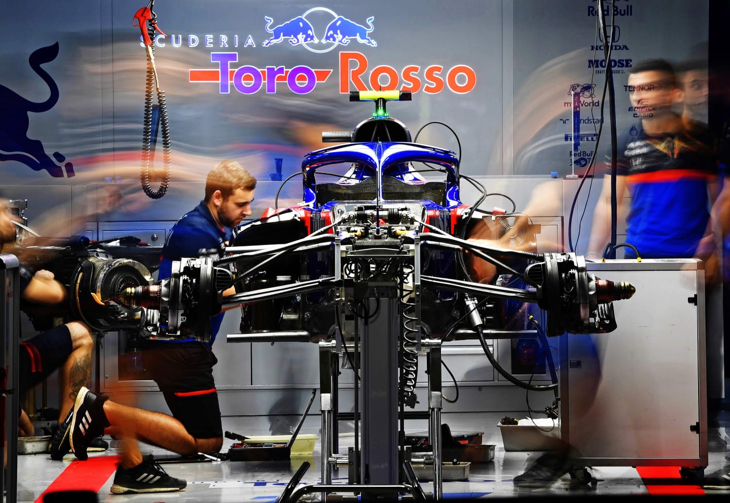 SUZUKA, JAPAN - OCTOBER 11: The Scuderia Toro Rosso team work in the garage after practice for the