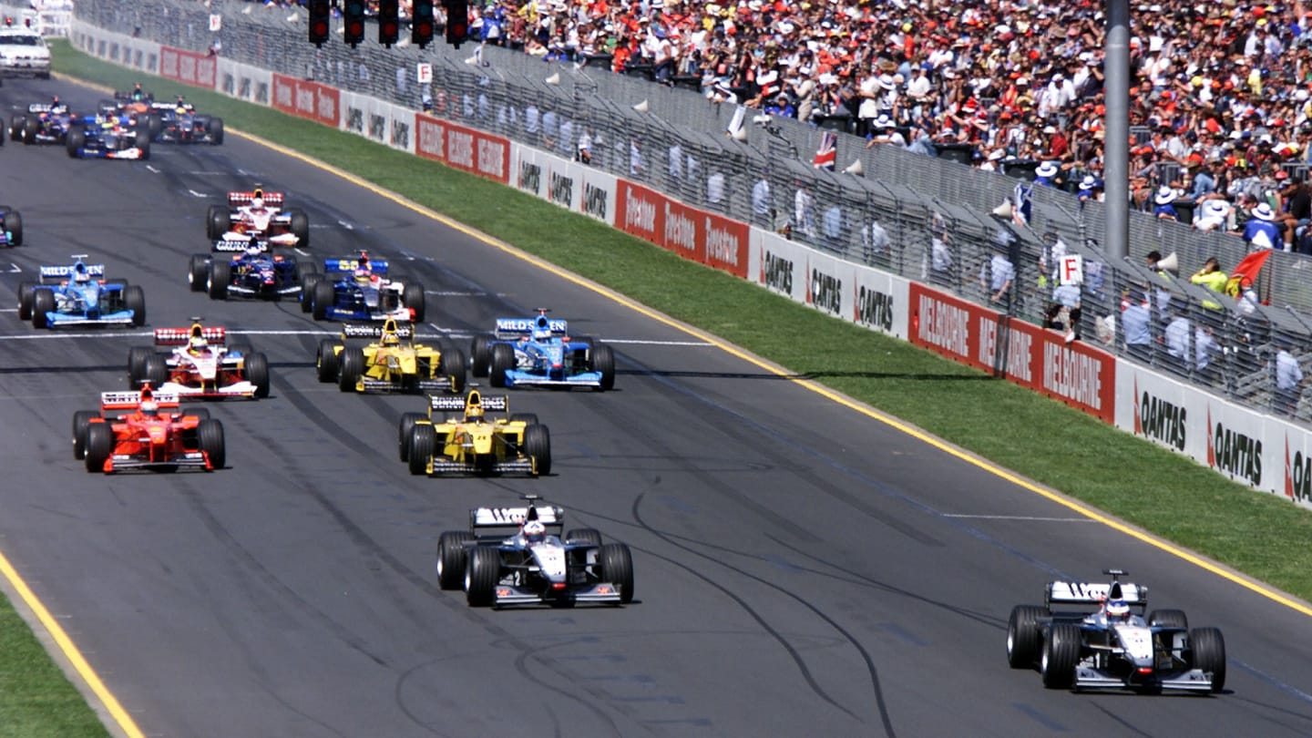 Reigning World Champion Mika Hakkinen (R front row) of Finland powers his McLaren-Mercedes ahead of