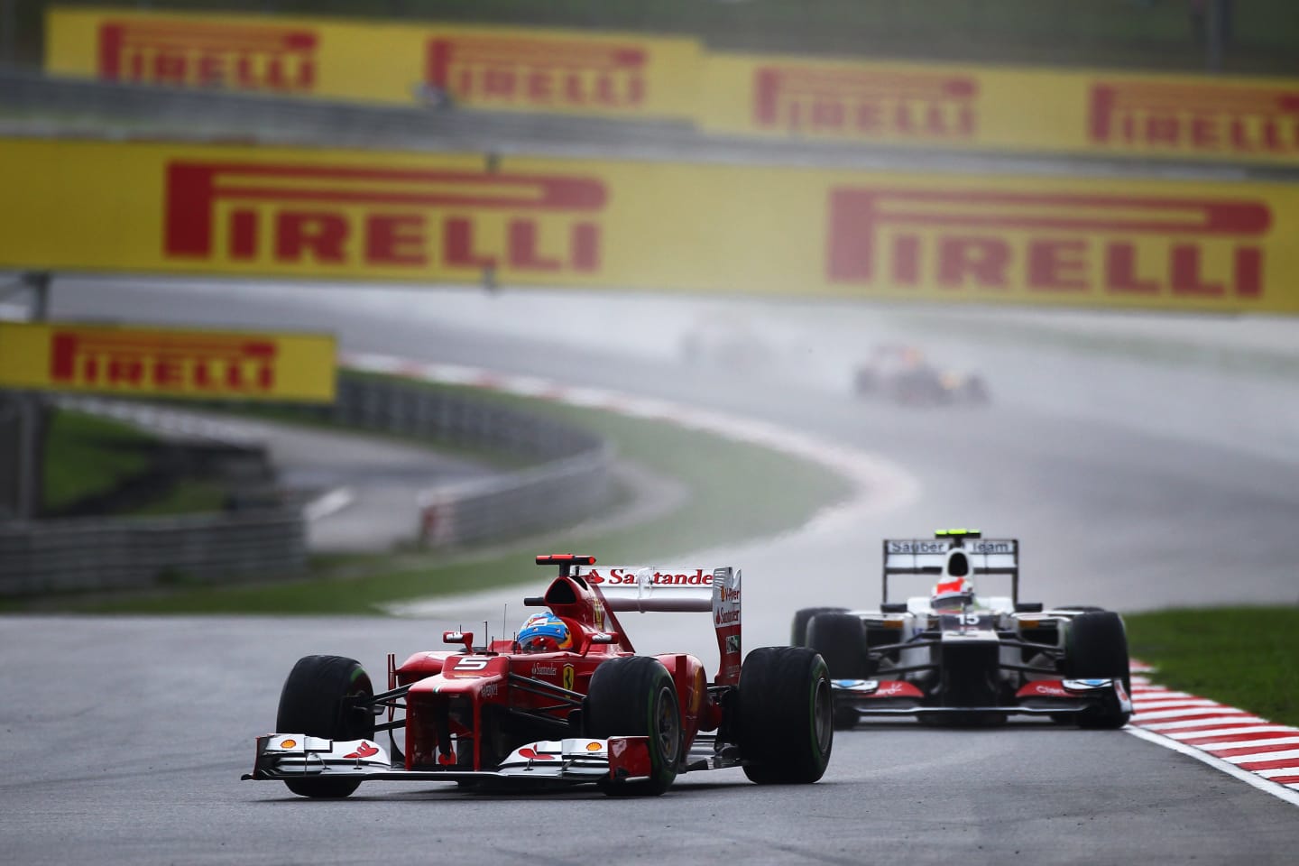 KUALA LUMPUR, MALAYSIA - MARCH 25:  Fernando Alonso of Spain and Ferrari holds off the challenge of