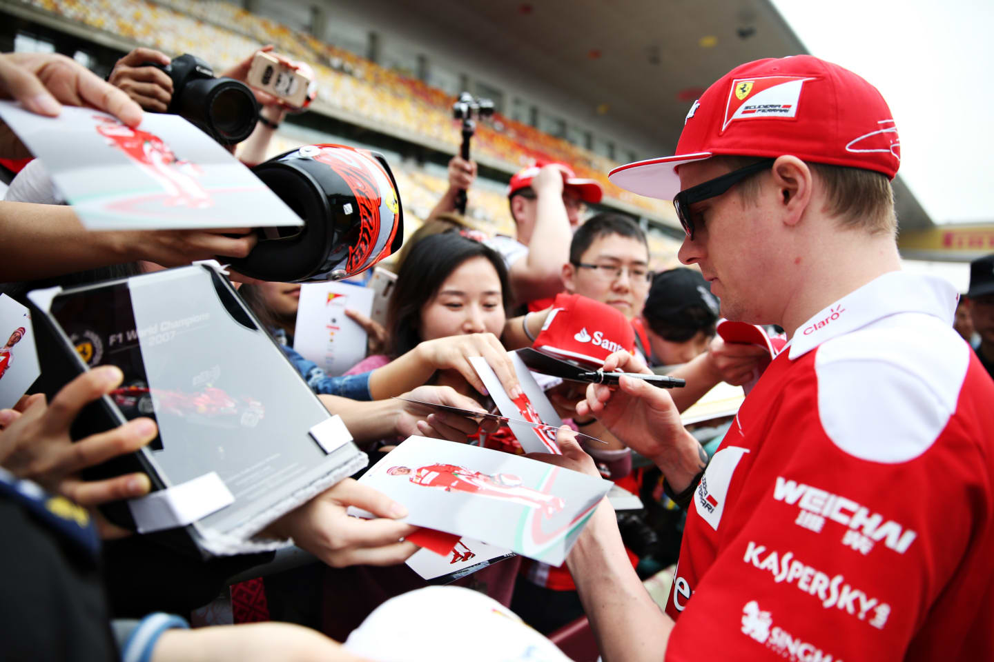 SHANGHAI, CHINA - APRIL 14: Kimi Raikkonen of Finland and Ferrari signs autographs for fans in the