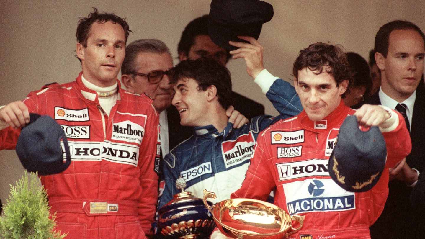 Brazilian Formula One champion Ayrton Senna (2ndR) waves to the crowd from the podium after winning