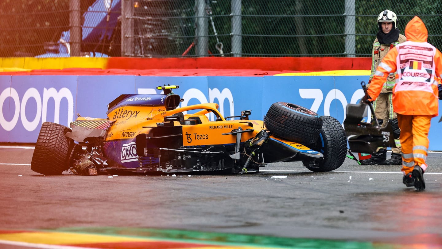 TOPSHOT - Race marshalls and technicians clear the car McLaren's British driver Lando Norris after he crashed unthe qualifying session of the Formula One Belgian Grand Prix at the Spa-Francorchamps circuit in Spa on August 28, 2021. (Photo by KENZO TRIBOUILLARD / AFP) (Photo by KENZO TRIBOUILLARD/AFP via Getty Images)
