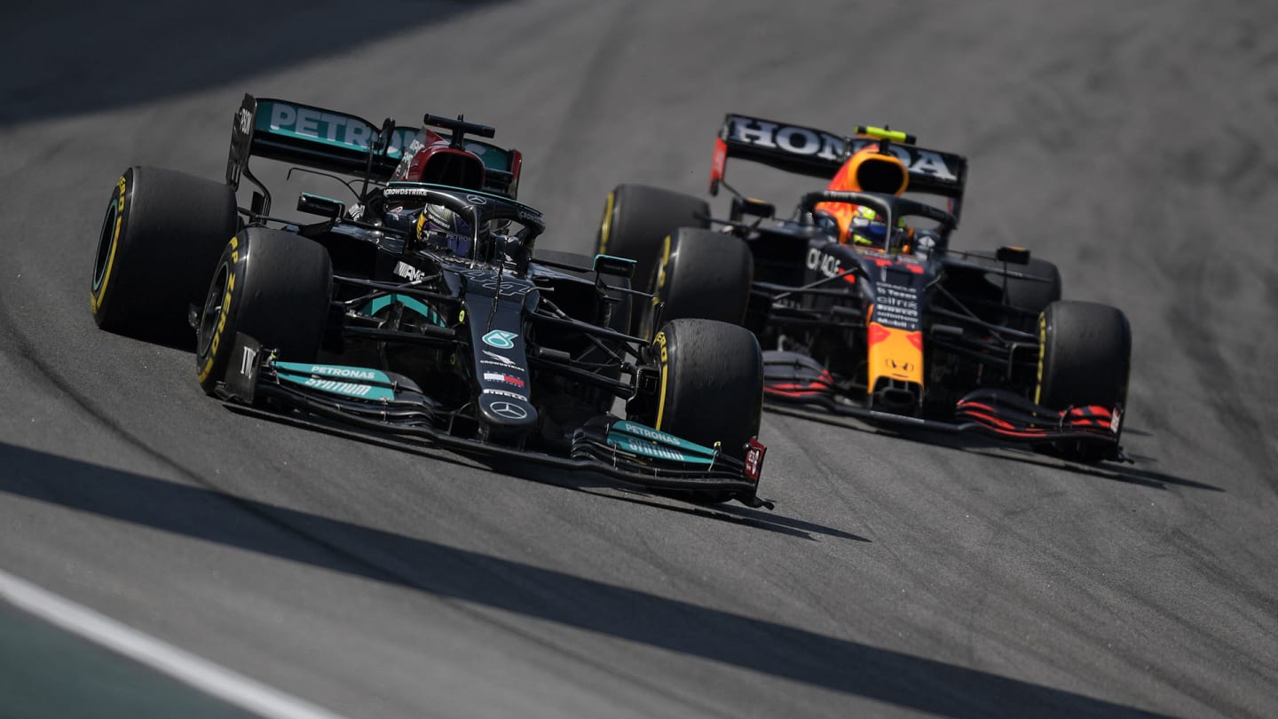 Mercedes' British driver Lewis Hamilton (L) passes Red Bull's Mexican driver Sergio Perez during