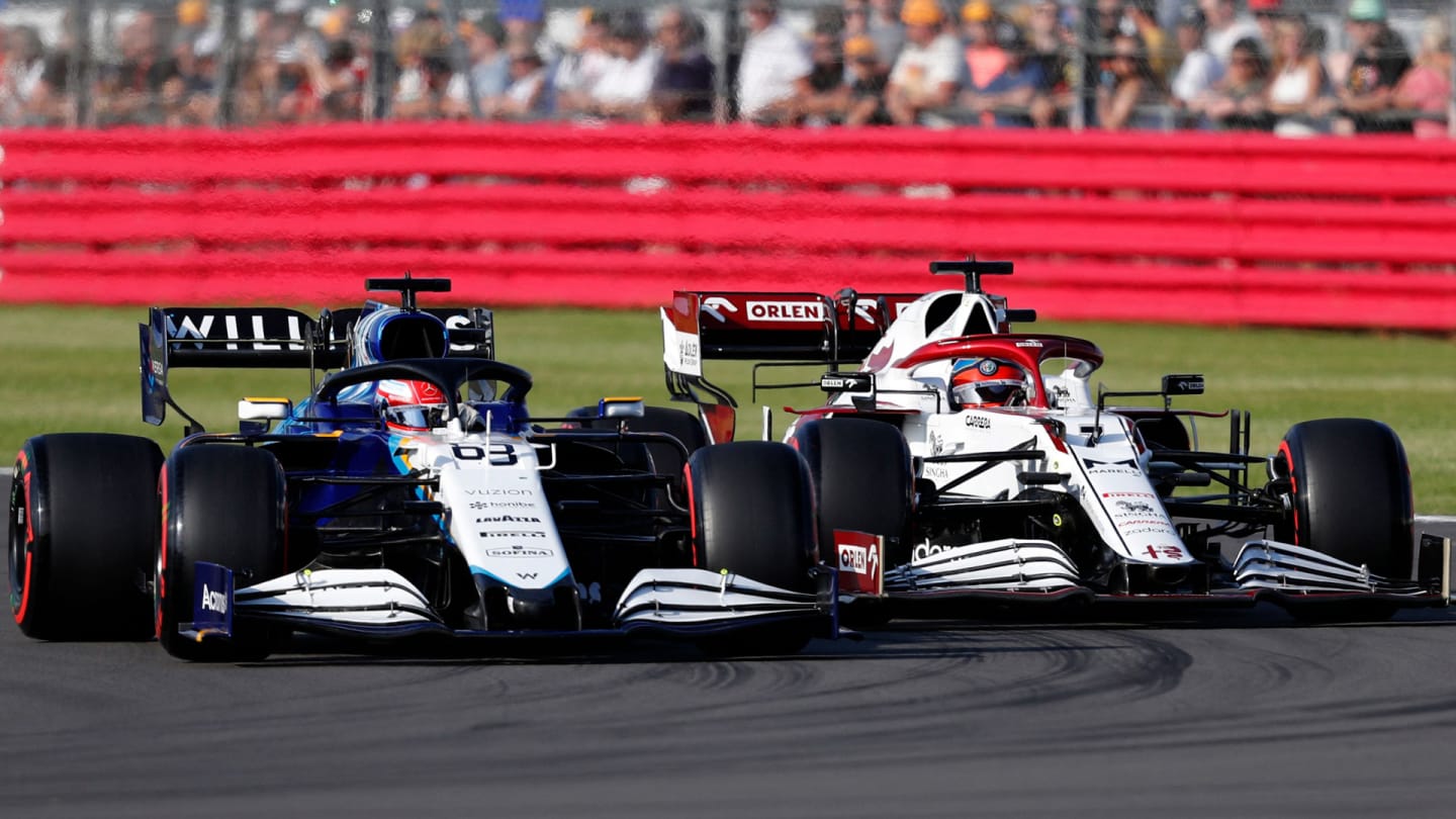 Williams' British driver George Russell (L) and Alfa Romeo's Finnish driver Kimi Raikkonen drive at