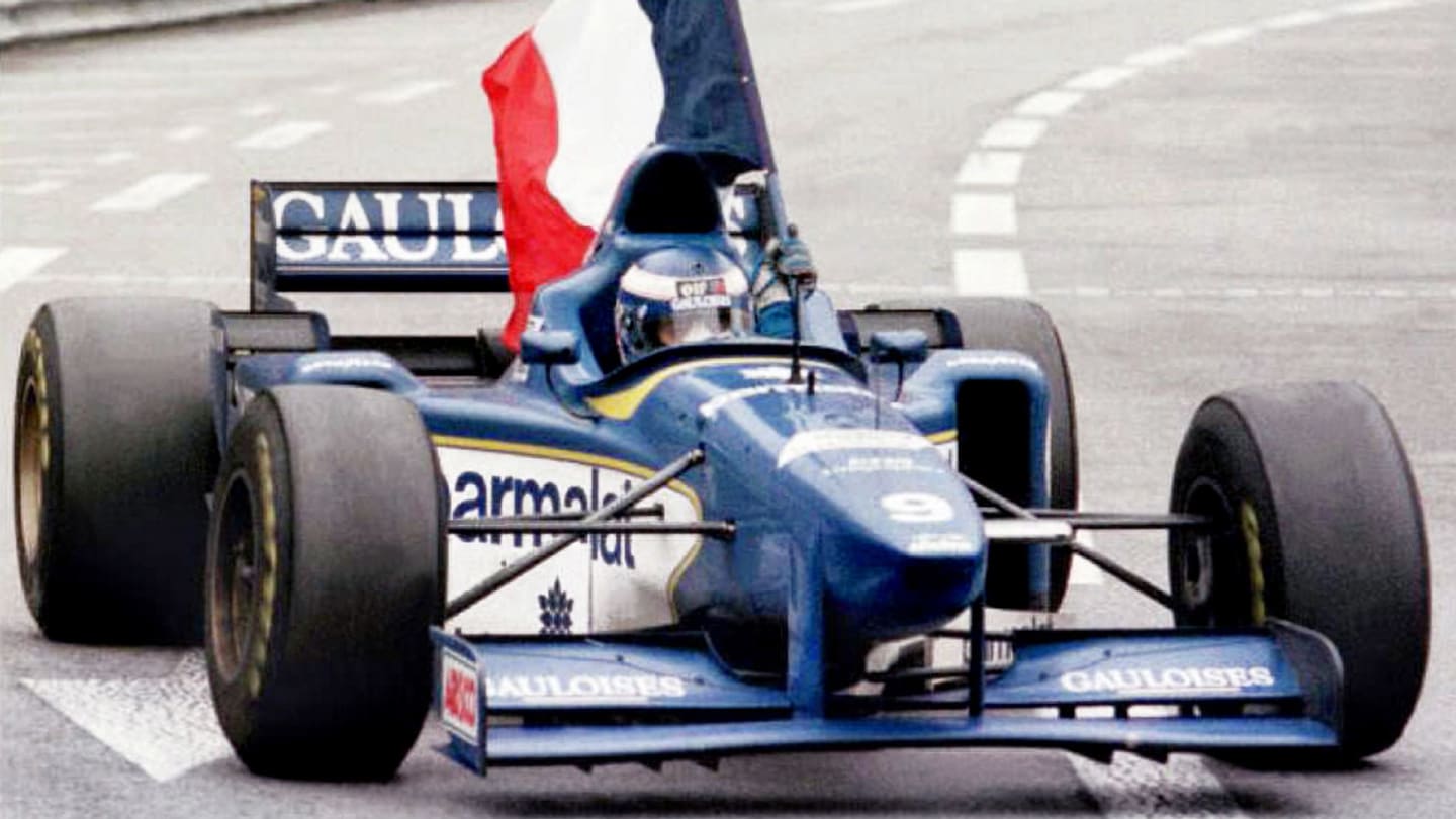 France's Olivier Panis, driving a Ligier Honda, brings out the French flag 19 May 1965 after