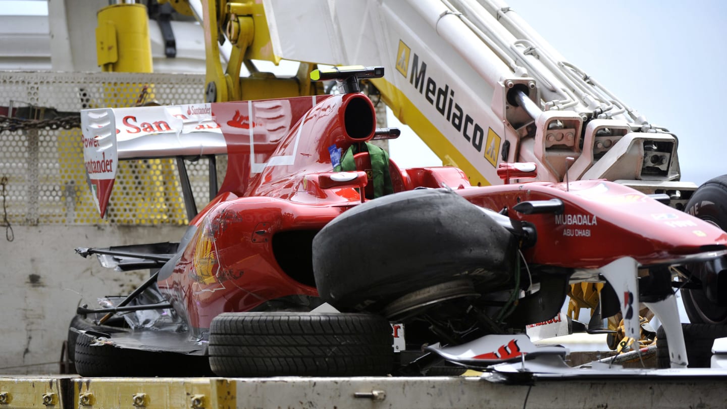 A truck carries the damaged car of Ferrari's Spanish driver Fernando Alonso after he crashed at the