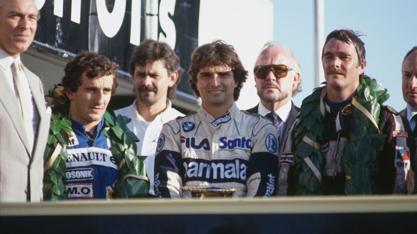 View of the winners of the 1983 European Grand Prix posed together on the podium, with from left,