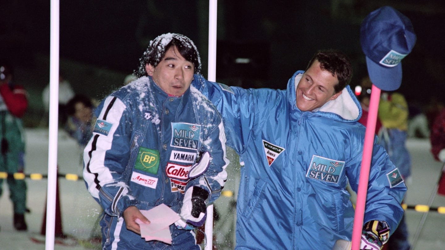 German driver Michael Schumacher (R) spatters a snowball over the head of Japanese driver Ukyo