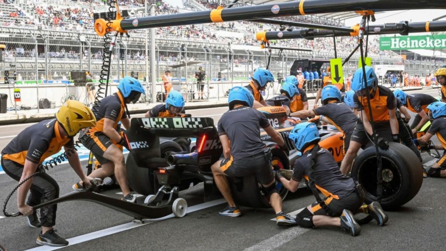 Mechanics practice pit-stop techniques with the car of McLaren's British driver Lando Norris during