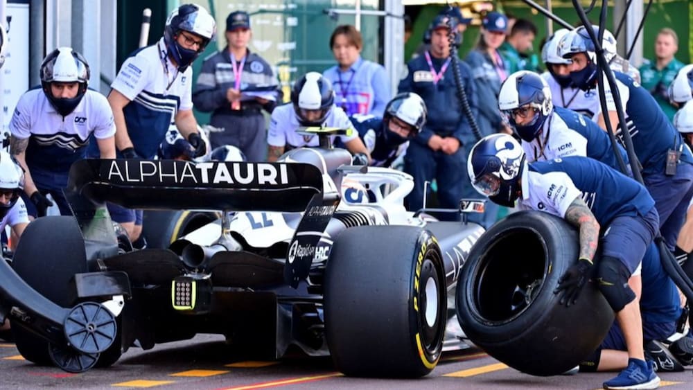 Pit crew change a tyre on the car of Alpha Tauri Japanese driver Yuki Tsunoda during the second
