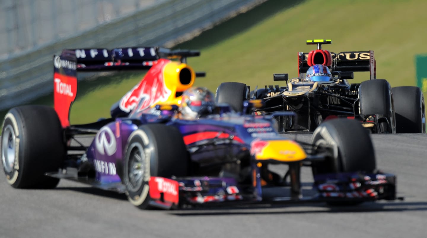 Infiniti Red Bull driver Sebastian Vettel of Germany is followed by Lotus driver Romain Grossjean