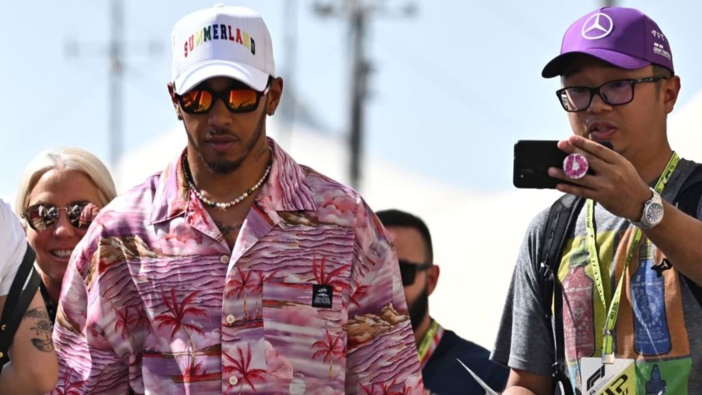 Mercedes' British driver Lewis Hamilton (L) arrives before the first practice session ahead of the