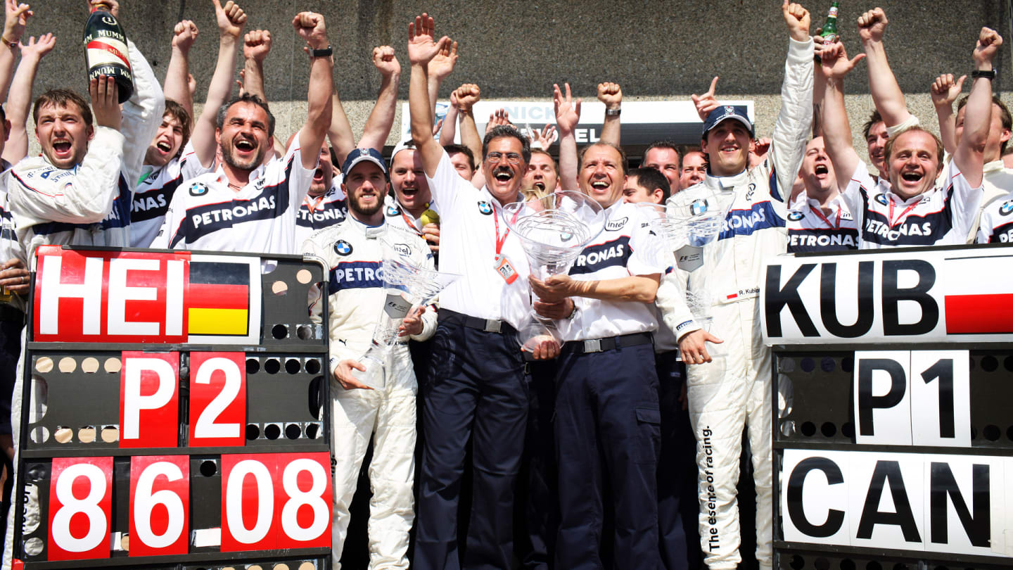 BMW Sauber team members Nick Heidfeld (centre left blue cap), Mario Theissen (centre left holding