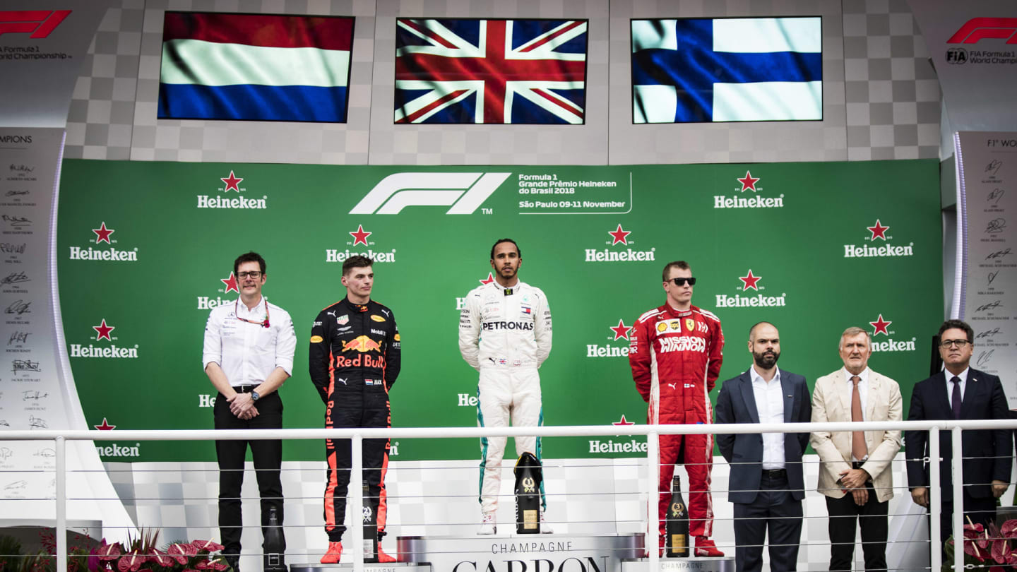 Andrew Shovlin, Chief Race Engineer, Mercedes AMG, Max Verstappen, Red Bull Racing, 2nd position, Lewis Hamilton, Mercedes AMG F1, 1st position, and Kimi Raikkonen, Ferrari, 3rd position, on the podium during the Brazilian GP on November 11, 2018 in Autodromo Jose Carlos Pace, Brazil. (Photo by Glenn Dunbar / LAT Images)
