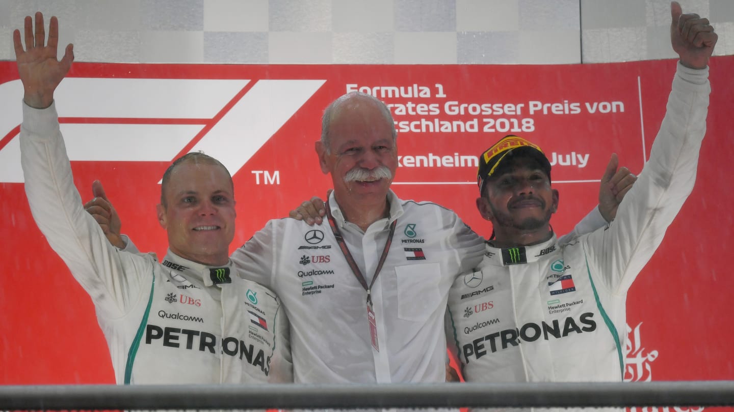 The iconic whiskers in between Valtteri Bottas and Lewis Hamilton belong to Dr. Dieter Zetsche, Chairman of the Board of Management of Daimler AG and Head of Mercedes-Benz Cars