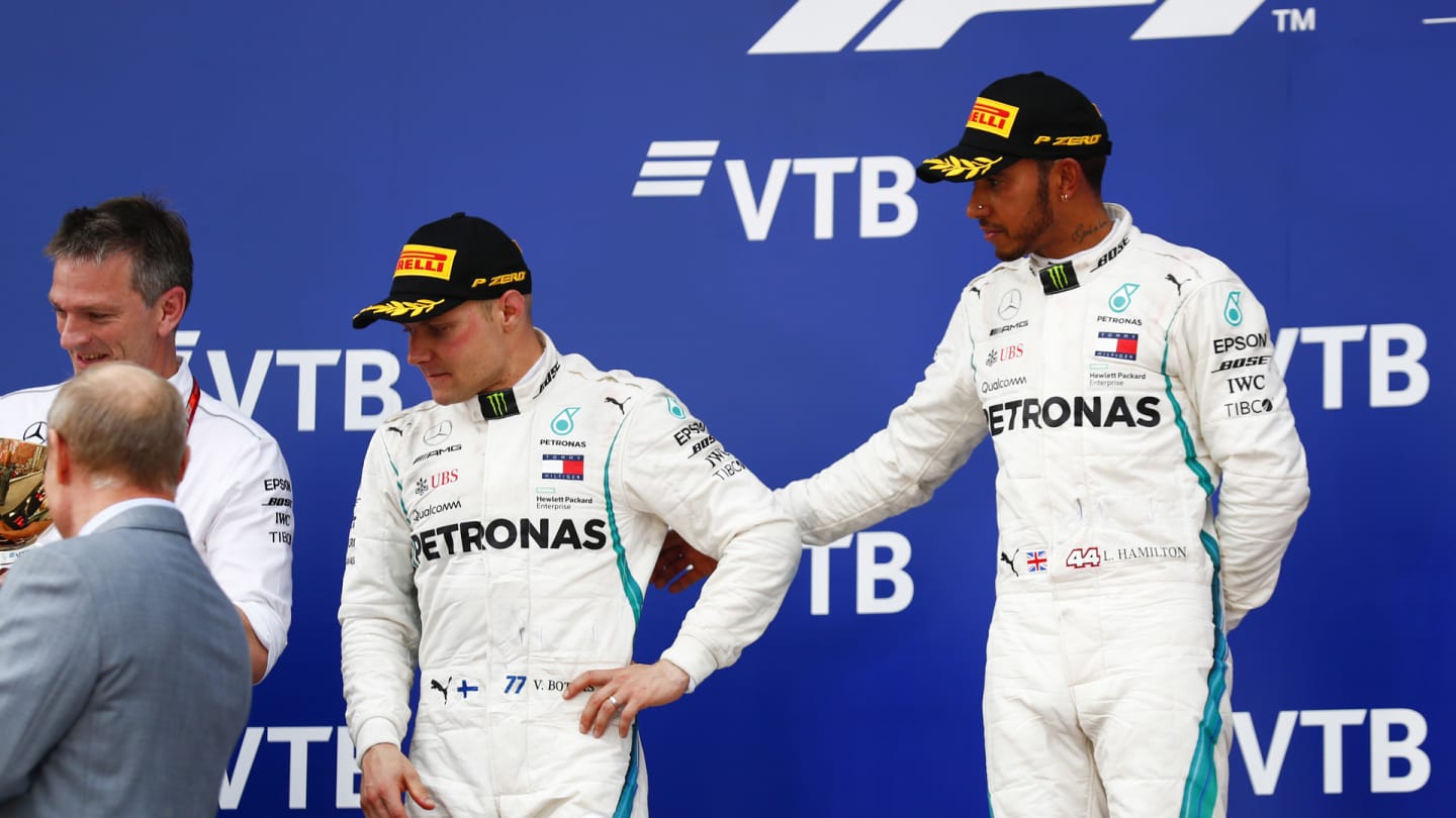 SOCHI AUTODROM, RUSSIAN FEDERATION - SEPTEMBER 30: Lewis Hamilton, Mercedes AMG F1, 1st position, consoles team mate Valtteri Bottas, Mercedes AMG F1, 2nd position, on the podium during the Russian GP at Sochi Autodrom on September 30, 2018 in Sochi Autodrom, Russian Federation. (Photo by Sam Bloxham / LAT Images)