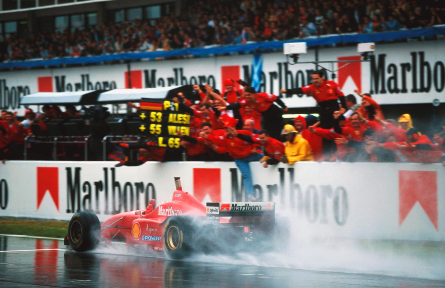 Race winner Michael Schumacher (GER) Ferrari F310 takes the adulation of his team from the pit wall