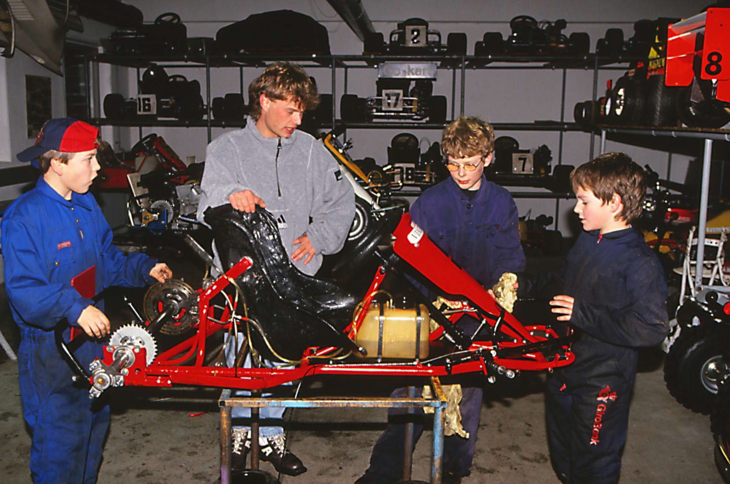 Jan Magnussen (DEN), centre, teaches the mechanics of a go-kart to young