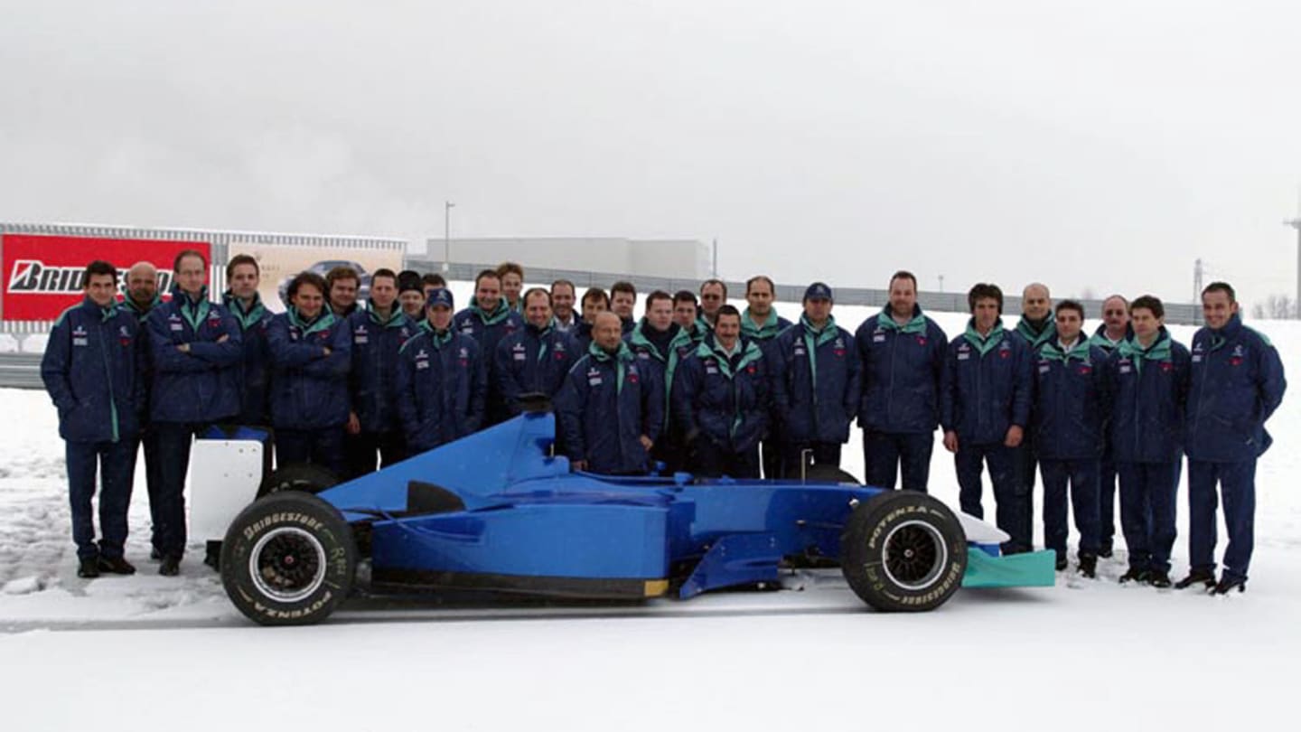 Sauber team members grit their teeth as they brave the icy conditions to display the brand new Sauber C22 at a snowy Fiorano in January 2003. © Sutton Motorsport Images