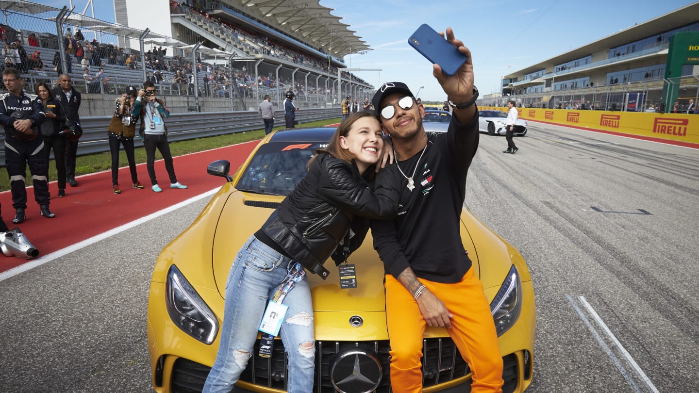 CIRCUIT OF THE AMERICAS, UNITED STATES OF AMERICA - OCTOBER 21: Lewis Hamilton, Mercedes AMG F1, takes a photo with actress Millie Bobby Brown during the United States GP at Circuit of the Americas on October 21, 2018 in Circuit of the Americas, United States of America. (Photo by Steve Etherington / LAT Images)