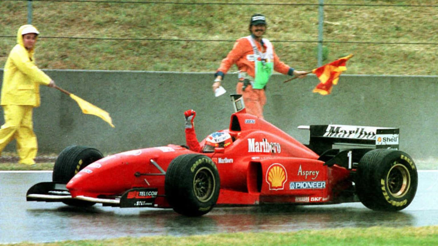 Germany's Ferrari driver Michael Schumacher crosses the finish line clenching his fist in victory