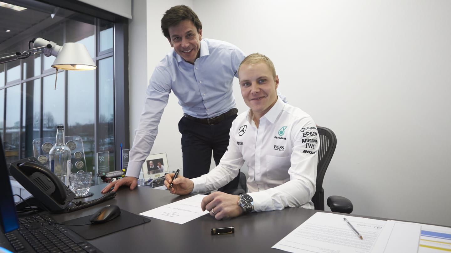 New Mercedes driver Valtteri Bottas signs his contract alongside Head of Mercedes-Benz motorsport Toto Wolff. © Daimler AG