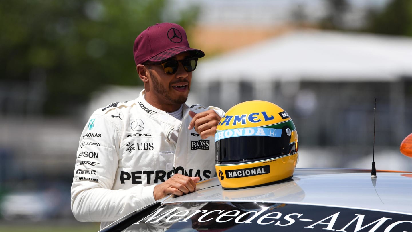 Pole sitter Lewis Hamilton (GBR) Mercedes AMG F1 celebrates on the Medical Car with the helmet of
