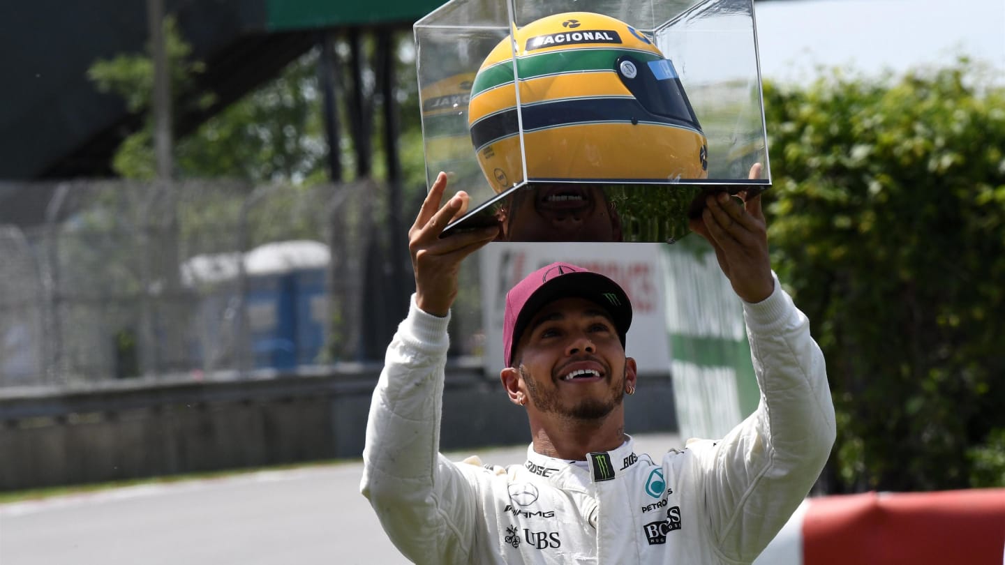 Pole sitter Lewis Hamilton (GBR) Mercedes AMG F1 celebrates with the helmet of Ayrton Senna at