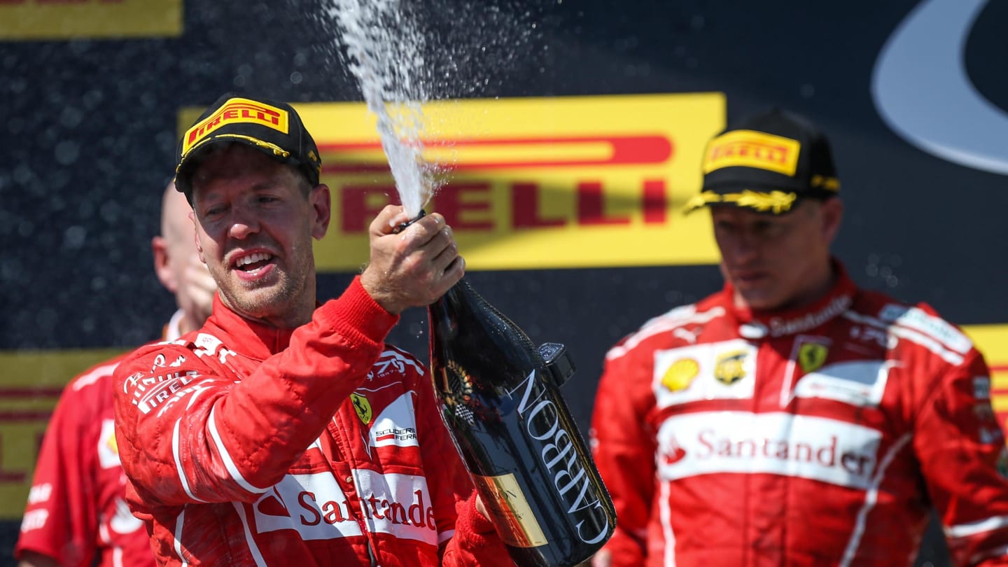 race winner Sebastian Vettel (GER) Ferrari celebrates on the podium with the champagne at Formula