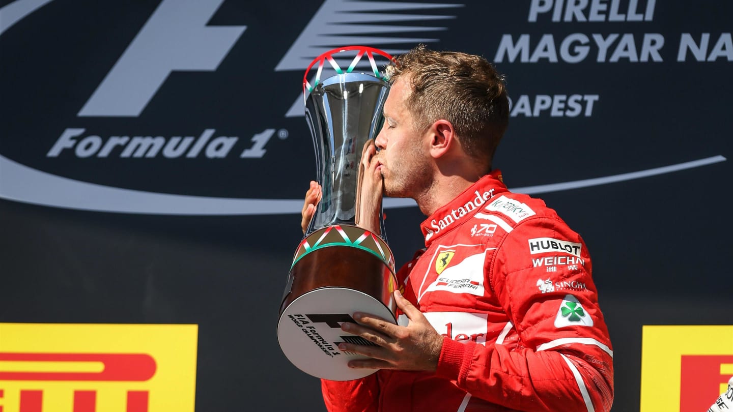 race winner Sebastian Vettel (GER) Ferrari celebrates on the podium and kisses the trophy at Formula One World Championship, Rd11, Hungarian Grand Prix, Race, Hungaroring, Hungary, Sunday 30 July 2017. © Sutton Images