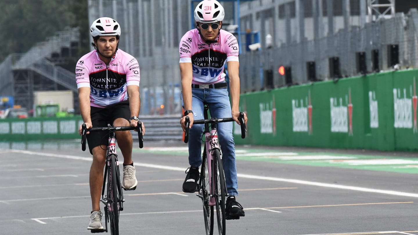 Sergio Perez (MEX) Force India and Esteban Ocon (FRA) Force India F1 cycle the track at Formula One