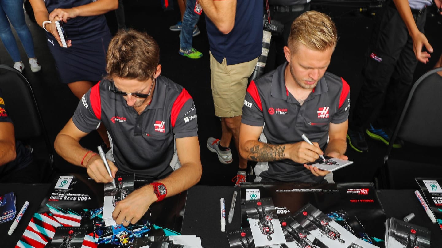 Romain Grosjean (FRA) Haas F1 and Kevin Magnussen (DEN) Haas F1 sign autographs for the fans at