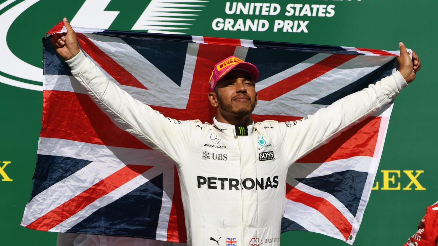 Race winner Lewis Hamilton (GBR) Mercedes AMG F1 celebrates on the podium with the Union flag at
