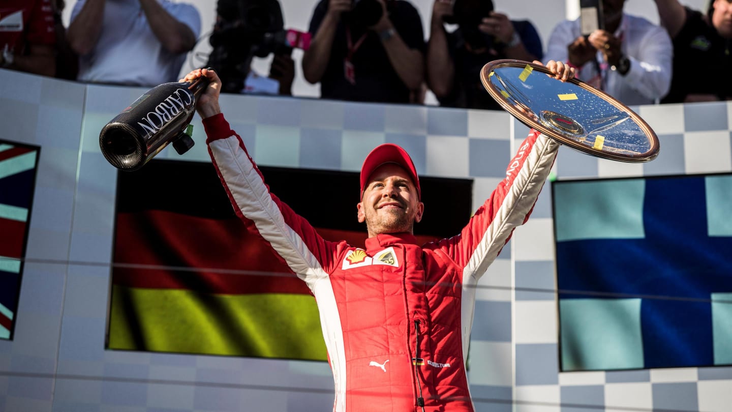 Race winner Sebastian Vettel (GER) Ferrari celebrates on the podium with the trophy and the
