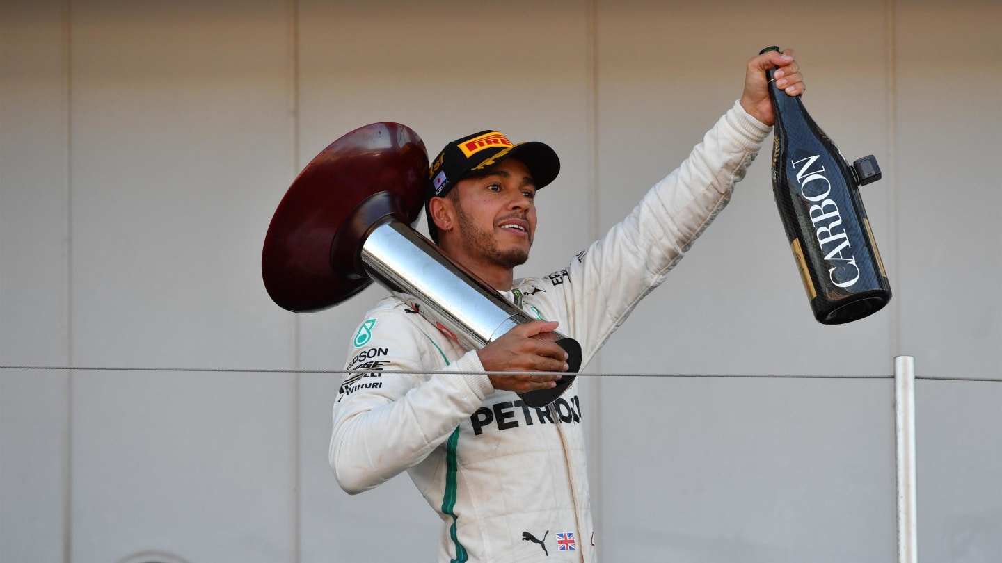 Lewis Hamilton, Mercedes AMG F1 celebrates with the trophy and the champagne on the podium at