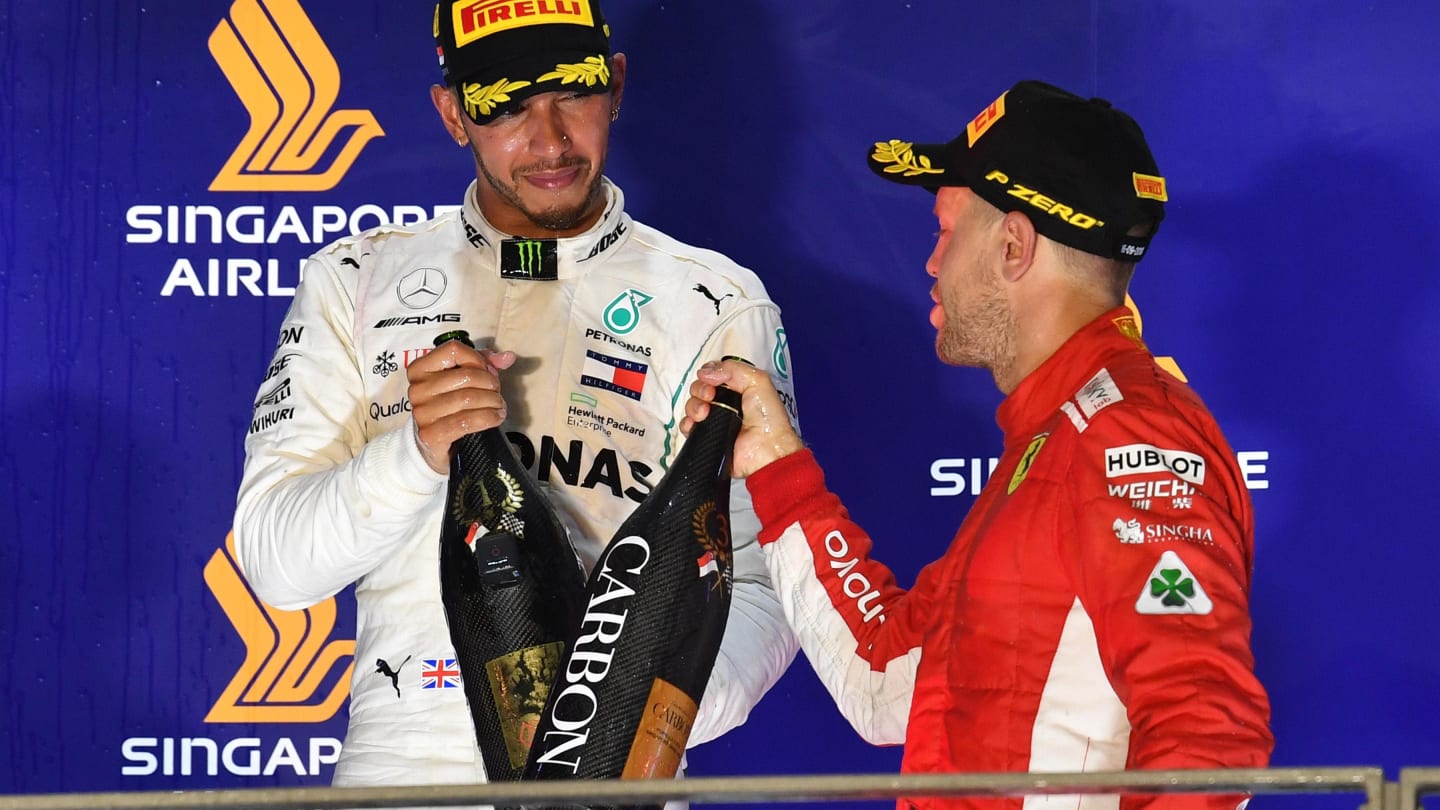 Lewis Hamilton, Mercedes AMG F1 and Sebastian Vettel, Ferrari celebrate on the podium with the champagne at Formula One World Championship, Rd15, Singapore Grand Prix, Race, Marina Bay Circuit, Singapore, Sunday 16 September 2018.