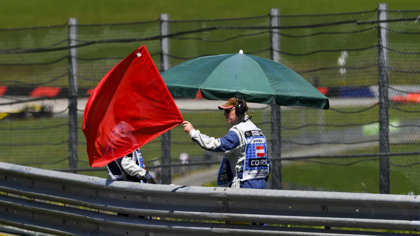 RED BULL RING, AUSTRIA - JUNE 28: Marshal waves Red Flag during the Austrian GP at Red Bull Ring on