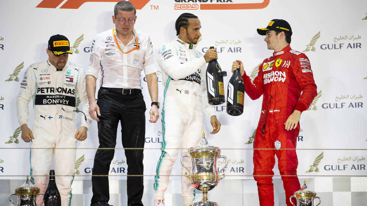 BAHRAIN INTERNATIONAL CIRCUIT, BAHRAIN - MARCH 31: Valtteri Bottas, Mercedes AMG F1, 2nd position, Andy Cowell, Managing Director, HPP, Mercedes AMG, Lewis Hamilton, Mercedes AMG F1, 1st position, and Charles Leclerc, Ferrari, 3rd position, on the podium during the Bahrain GP at Bahrain International Circuit on March 31, 2019 in Bahrain International Circuit, Bahrain. (Photo by Glenn Dunbar / LAT Images)