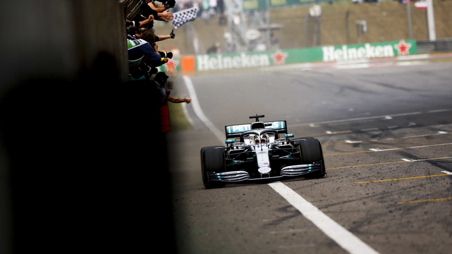 SHANGHAI INTERNATIONAL CIRCUIT, CHINA - APRIL 14: Lewis Hamilton, Mercedes AMG F1 W10, 1st position, crosses the line for victory to the delight of his team on the pit wall during the Chinese GP at Shanghai International Circuit on April 14, 2019 in Shanghai International Circuit, China. (Photo by Andy Hone / LAT Images)