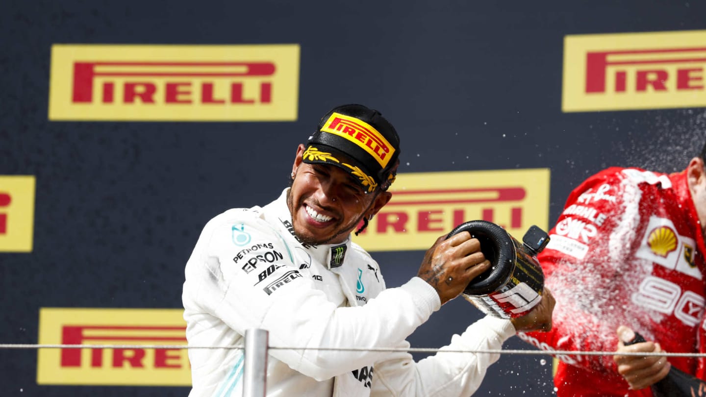 CIRCUIT PAUL RICARD, FRANCE - JUNE 23: Lewis Hamilton, Mercedes AMG F1, 1st position, and Charles Leclerc, Ferrari, 3rd position, spray Champagne on the podium during the French GP at Circuit Paul Ricard on June 23, 2019 in Circuit Paul Ricard, France. (Photo by Joe Portlock / LAT Images)
