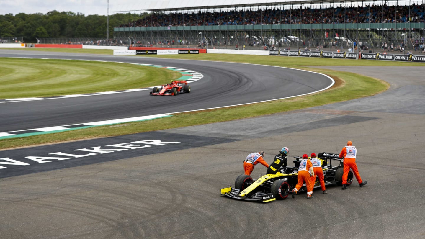 SILVERSTONE, UNITED KINGDOM - JULY 12: Charles Leclerc, Ferrari SF90 passing the car of Daniel Ricciardo, Renault R.S.19 being pushed by marshals after stopping on track during the British GP at Silverstone on July 12, 2019 in Silverstone, United Kingdom. (Photo by Glenn Dunbar / LAT Images)